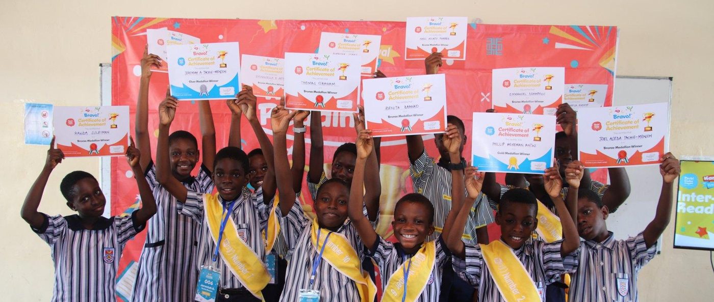 Learners in Reading Champion sashes holding up their Perbi Cubs certificates of achievement
